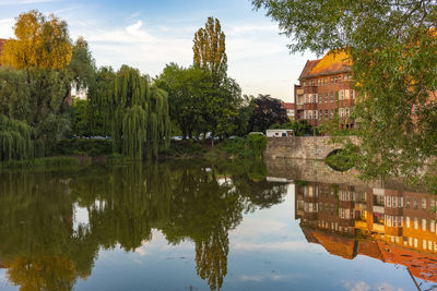 Reflection of trees and buildings on lake