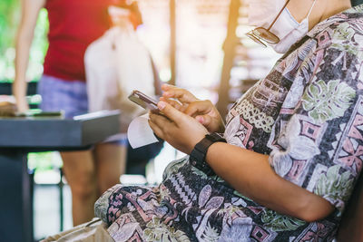 Midsection of woman using mobile phone