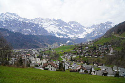 Scenic view of townscape and mountains against sky