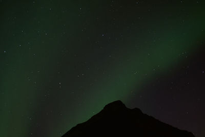 Low angle view of silhouette mountain against sky at night