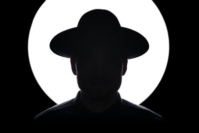 Rear view of silhouette man against black background