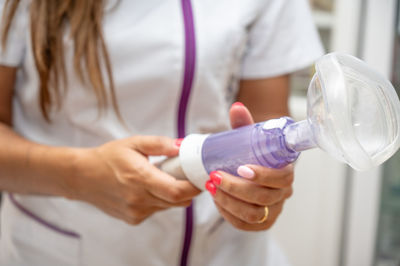 Midsection of woman holding bottle