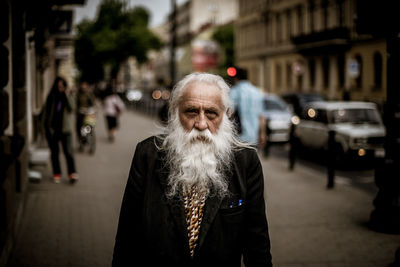 Man with umbrella standing on street in city