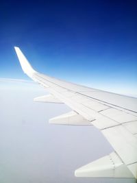Aerial view of airplane wing against clear blue sky