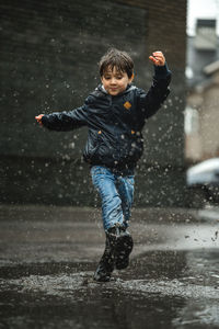 Full length of boy standing on puddle