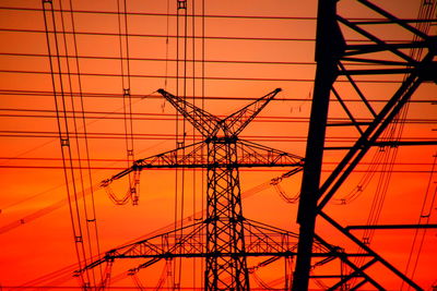 Low angle view of electricity pylon against sky on red and orange underground