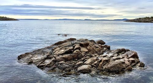 Scenic view of rocks on beach against sky