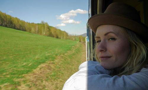 Close-up of smiling young woman sitting in train