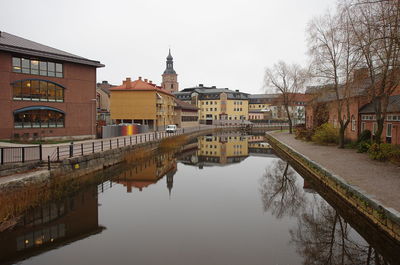 Canal amidst buildings against sky in city