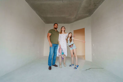 Portrait of friends standing against wall