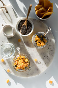 Above view of a marble board topped with mango chia puddings and all the fixings