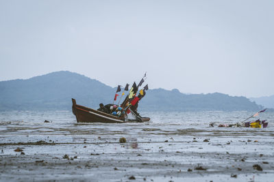 Fishing boat on sea against sky