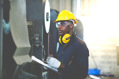 Engineer holding clipboard in factory