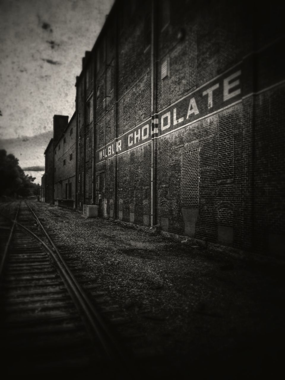 railroad track, architecture, rail transportation, built structure, public transportation, transportation, railroad station, building exterior, railroad station platform, train - vehicle, the way forward, graffiti, diminishing perspective, text, travel, no people, indoors, day, building