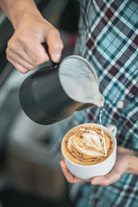 Cropped image of hand holding coffee cup