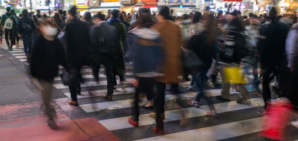 People walking on zebra crossing in city