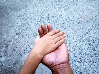 Close-up of hands of a person and a boy