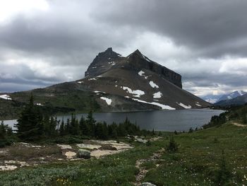 Scenic view of mountains and lake against cloudy sky