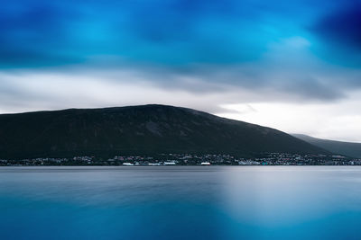 Scenic view of sea and mountains against blue sky