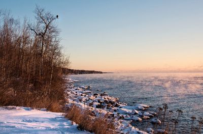 Scenic view of sea against sky at sunrise