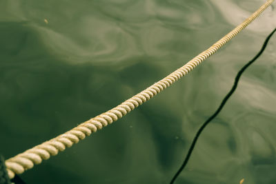 High angle view of rope tied to pole against sea