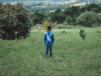 Rear view of man walking on field