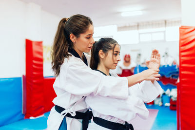 Instructor teaching martial arts to young woman