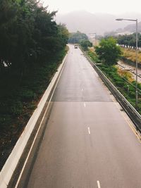 Road amidst trees against sky