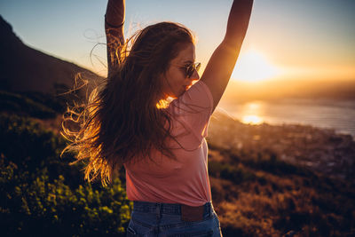 Woman standing against sky during sunset