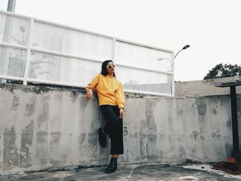 Full length of woman with umbrella against sky