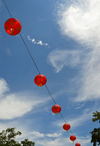 Low angle view of red lanterns hanging against sky