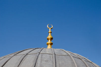 Low angle view of cross against clear blue sky