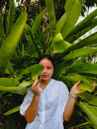 A girl under banana leaf