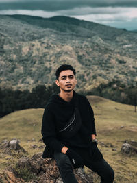 Portrait of young man standing on landscape