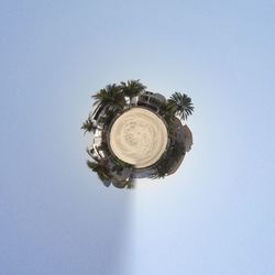 Little planet effect of houses and palm trees at beach against clear sky