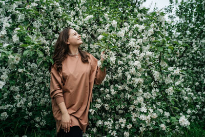 Beautiful girl in blooming apple tree aroma of flowers outdoor nature
