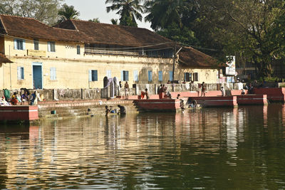 Group of people on boat in canal by building