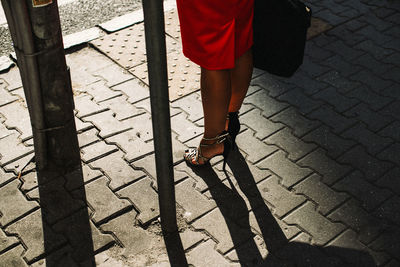 Low section of woman standing on footpath