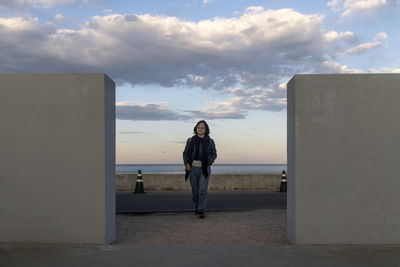 View of a woman at the seaside against the horizon over the sea