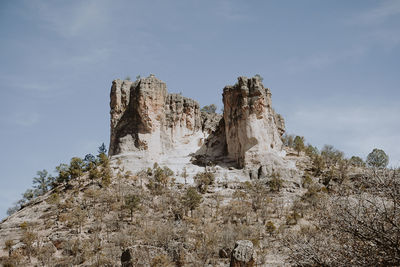 Low angle view of rock formation on land against sky