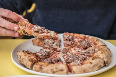 Close-up of hand holding pizza