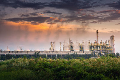 Panoramic view of factory against sky during sunset