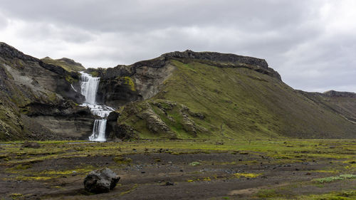 Scenic view of waterfall against sky