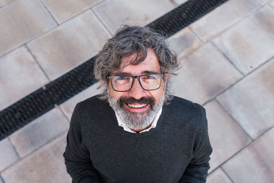 Portrait of young man standing against wall