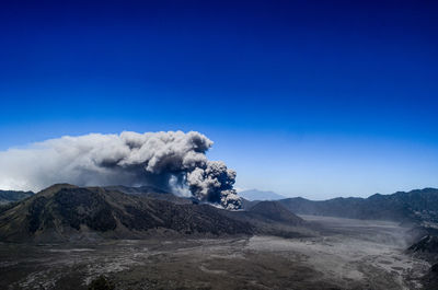 Smoke emitting from volcanic mountain against sky