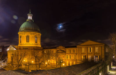 Low angle view of illuminated building against sky at night