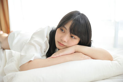 Young woman lying on bed at home