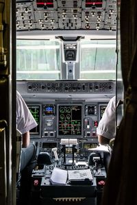 Midsection of pilot and co-pilot sitting in cockpit