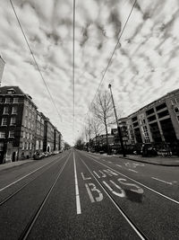 View of city street against cloudy sky