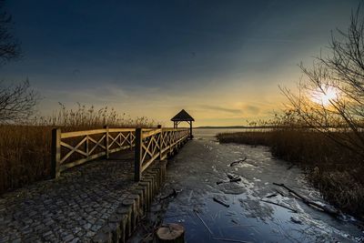 Scenic view of snow covered land against sky during sunset